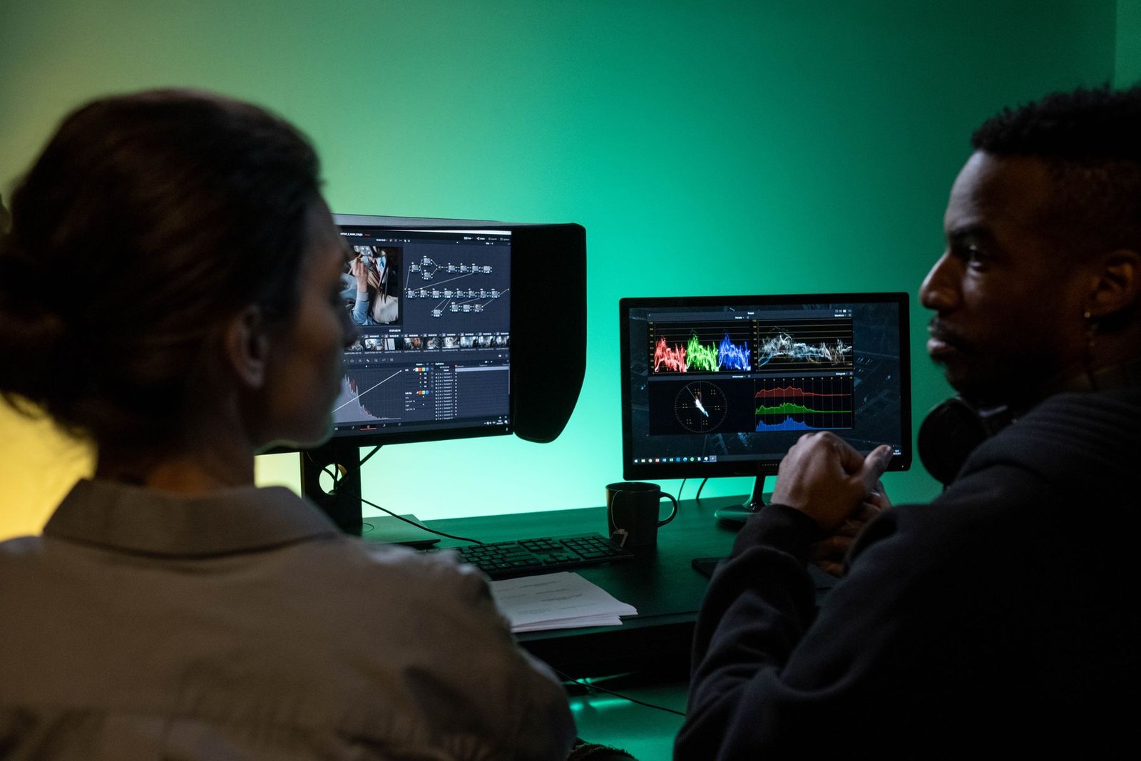 Fotografía de stock: dos profesionales revisan una edición de vídeo en un estudio