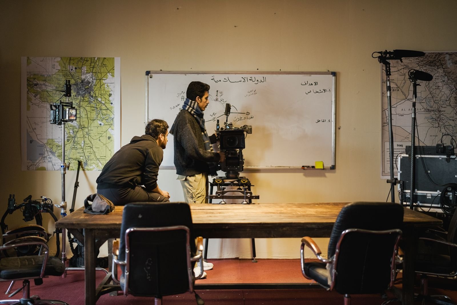 Dos profesionales preparan una cámara de cine en un plató interior